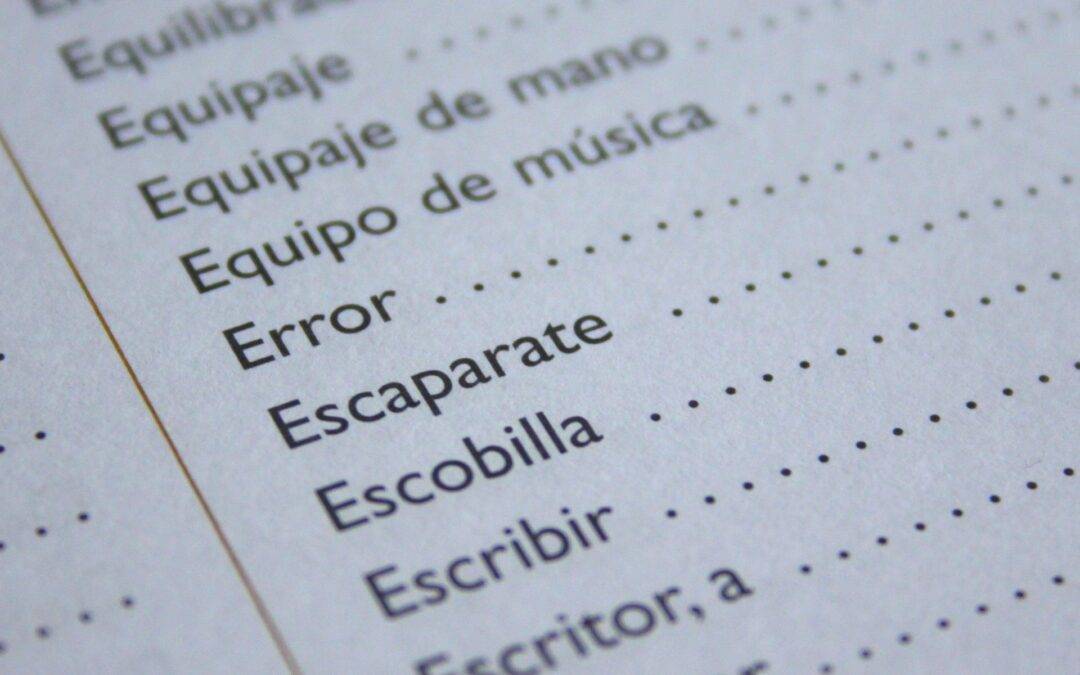 Close-up of a dictionary page showing Spanish words like 'Equipaje de mano', 'Escribir' and 'Escaparate'.