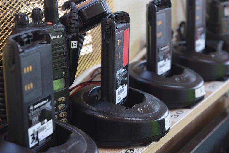Row of Motorola handheld radios in their charging docks on a store shelf, labeled with numbers in the foreground