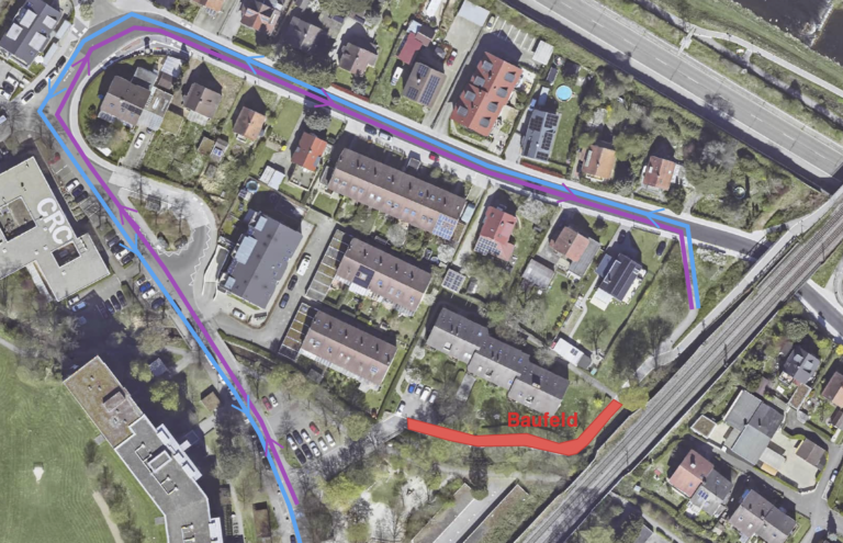 Aerial view of a residential area with blue and purple route lines overlaid along streets and a red construction site label Bauefeld is visible nearby.