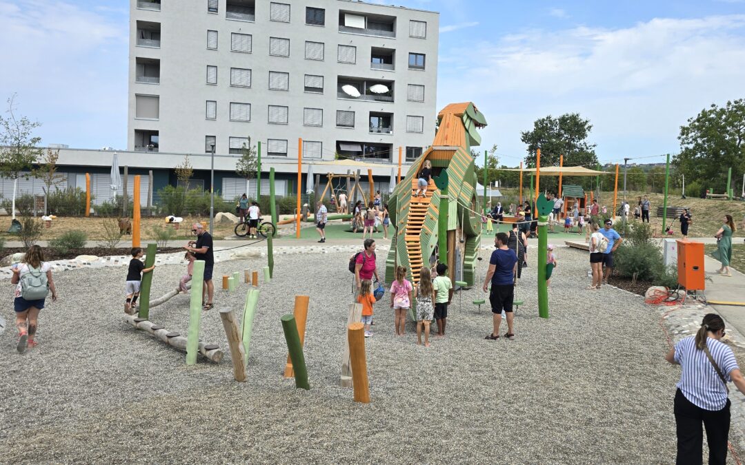 A crowded urban playground with a large grey apartment building in the background and a wooden dragon-shaped climbing structure in the center, kids and adults playing and walking around.