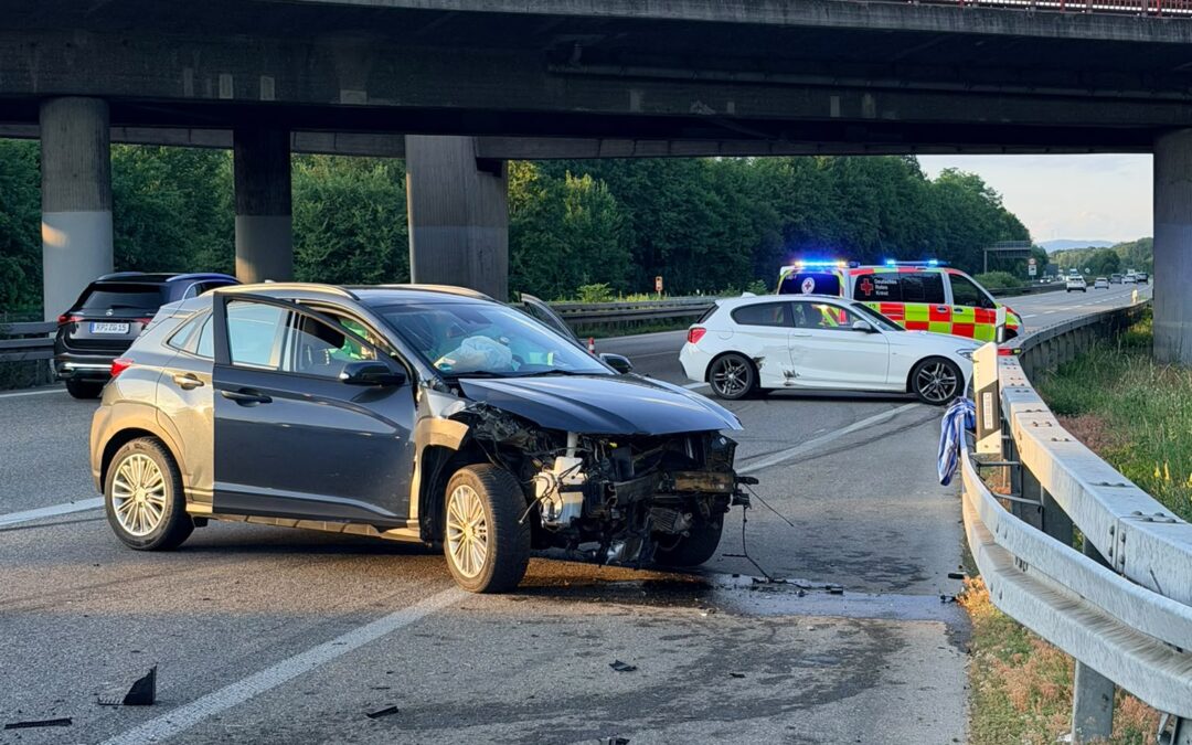 Cars involved in a multi-vehicle crash on a highway under an overpass, with debris scattered on the road and emergency vehicles in the distance