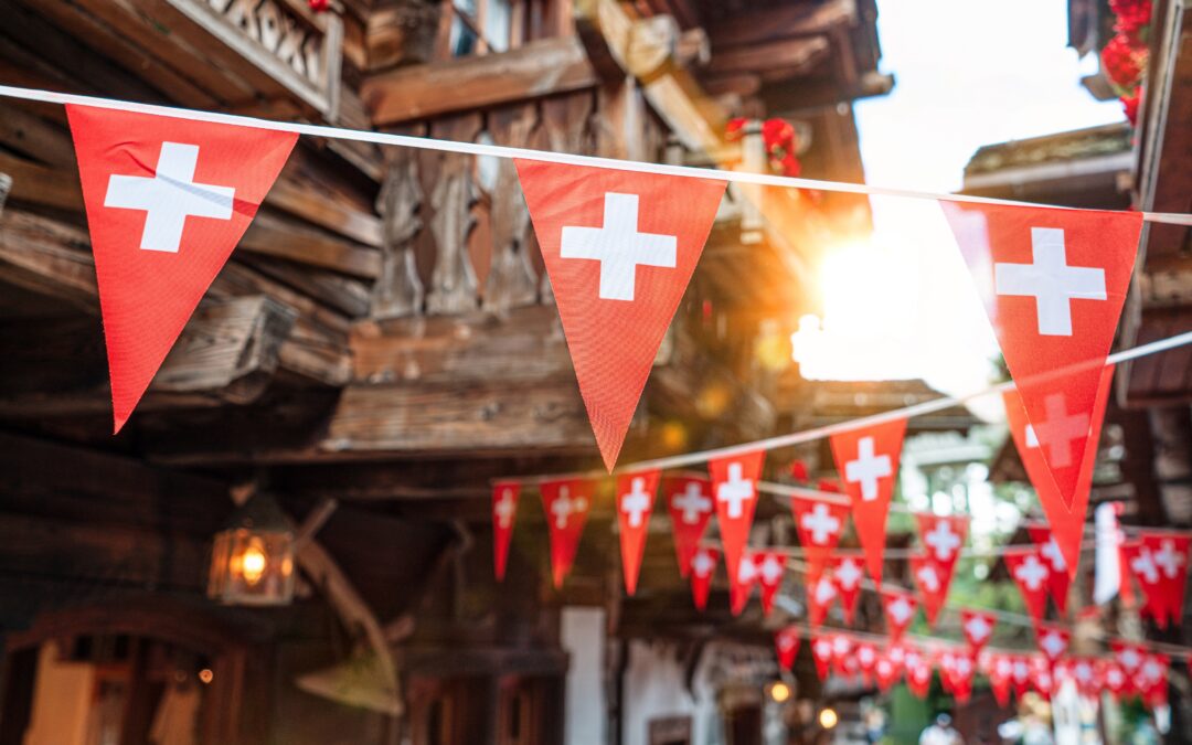 Red triangular bunting with white crosses strung across a rustic street.