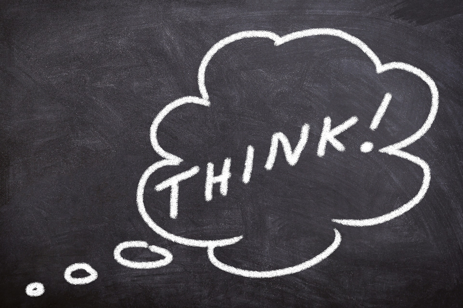 Chalk drawing of a thought bubble with the word THINK! on a dark chalkboard surface.
