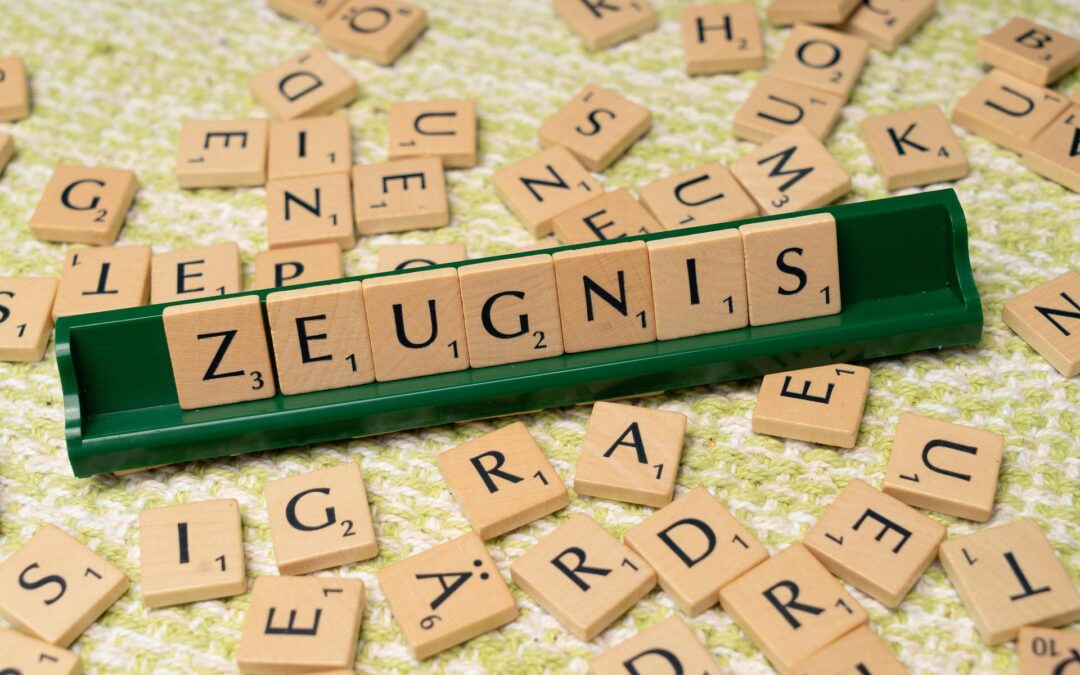 Scrabble tiles on a green rack spell 'ZEUGNIS' on a patterned surface.